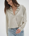 Woman wearing a striped shirt and jeans on a white background front view