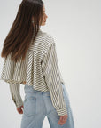 Woman wearing a striped shirt and jeans on a white background back view