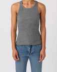 Person wearing a gray tank top and blue jeans on a white background