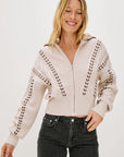 Woman wearing a beige zip-up sweater with details on a white background