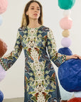 model wearing a print dress with art balls around her and a white background