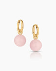Gold hoop earrings with pink spherical charms on a white background