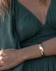 Lumi Cuff Bracelet in Gold front view on model in green dress