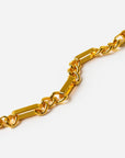A close-up of a polished gold-tone chain link bracelet featuring rectangular bar links alternating with smaller oval links, set against a clean white background.