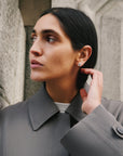 Mini Woven Square Earrings Silver on model with grey coat