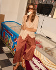 Woman eating ice cream in front of an ice cream freezer with Häagen-Dazs branding. full body view