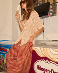 Woman in a polka dot outfit standing in front of a Häagen-Dazs display.
