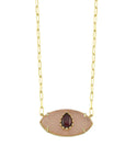 Necklace with a gold chain and eye-shaped pendant featuring a red gemstone on a white background
