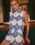 Woman wearing a blue and white patterned matching set in an indoor setting