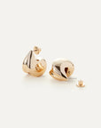 Paige Puff Earrings with one earring laying on its side with the backing off