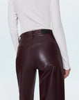 Brown leather pants worn by a person on a light blue background back view