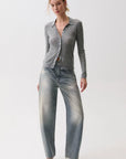 model wearing a rhinestone blue jean with a long sleeve grey top on a white background