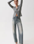 model wearing a rhinestone blue jean with a long sleeve grey top on a white background