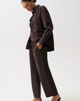 Person wearing a brown outfit on a white background