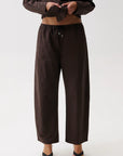 Model wearing brown theo pant on a white background