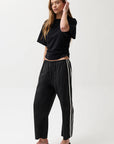 Woman wearing a black outfit with white stripes on a white background