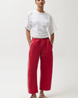 Person wearing a white t-shirt and red pants on a white background