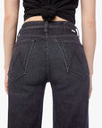 Woman wearing black tank top and jeans on a white background