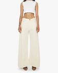 Woman wearing a white sleeveless top and cream-colored wide-leg pants on a white background