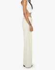 Person wearing a white sleeveless top and cream-colored wide-leg pants on a white background