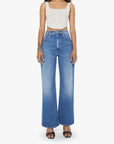 Woman wearing blue jeans and a white top on a white background