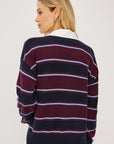 stripe polo top worn by a model with jeans on a grey background, back