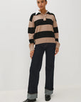 Person wearing a striped sweater and black pants on a white background
