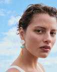 Woman wearing Luna Drop Earrings with a blue sky background