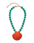 Necklace with turquoise beads and a red shell pendant on a white background
