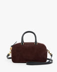 A dark brown suede handbag with black leather handles and a matching shoulder strap, accented by gold-tone hardware, shown against a plain white background.