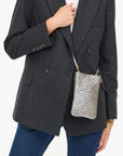 small poche silver bag crossbody on a model with a blazer and jeans