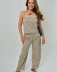 Woman wearing a beige checkered outfit with a white background