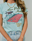 Person wearing a light blue t-shirt with a graphic design and text.