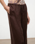Brown pants worn by a person on a plain background