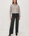 Woman wearing a striped shirt and black jeans on a white background front view