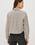 Person wearing a striped shirt and dark jeans on a white background back view