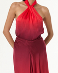 Woman wearing a red halter neck dress on a white background