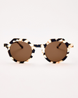 Round sunglasses with brown lenses and black and gold frame on a white background
