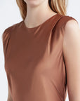 close up of shoulder pad detail on cinnamon colored dress on a model with a white background