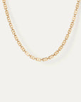 Gold chain necklace on a light beige background