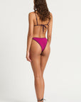model wearing a magenta bikini on white background, back view
