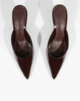 A pair of dark brown pointed-toe mule heels with a glossy finish, shown from a top-down perspective on a light gray background.