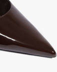 Close-up of a glossy dark brown pointed-toe shoe on a clean white background.
