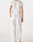 model wearing the simone white pant and a short sleeve with tee with a white background, back