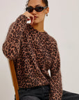 Person wearing a leopard print sweater against a plain background