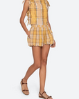 Woman wearing a yellow plaid dress on a white background