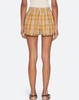 Person wearing yellow plaid shorts on a white background