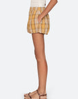 Person wearing yellow plaid shorts on a white background