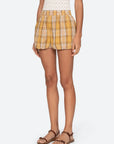 Person wearing a yellow plaid skirt on a white background