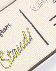 Close-up of a beaded handbag with text on fabric